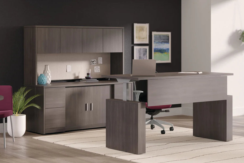 Modern office interior with gray furniture, red chairs, and large windows.